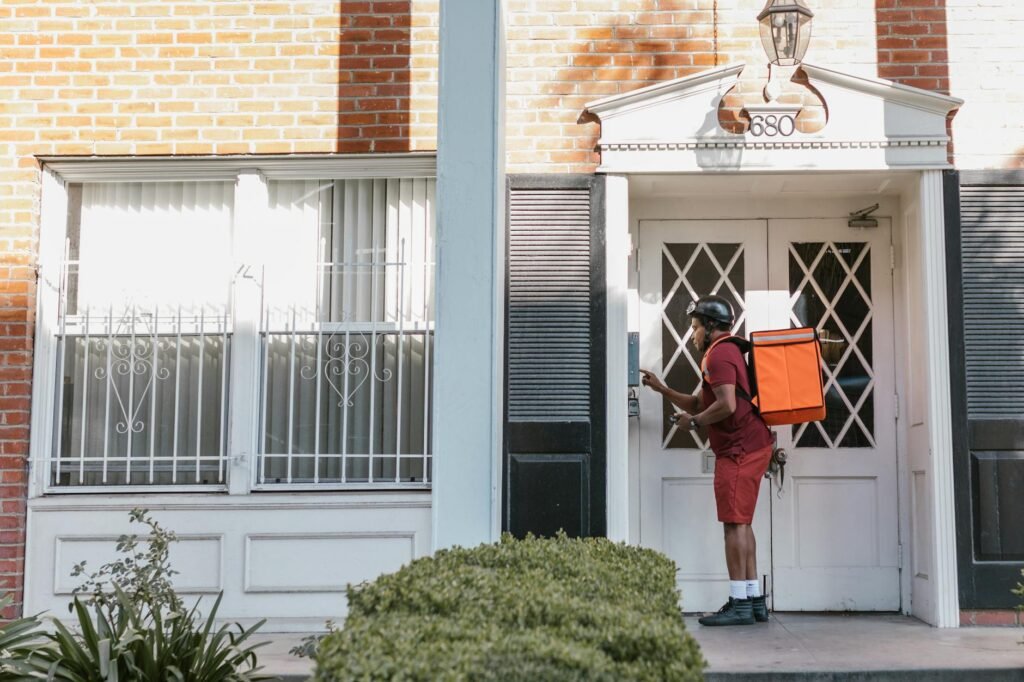 a deliveryman pressing the doorbell